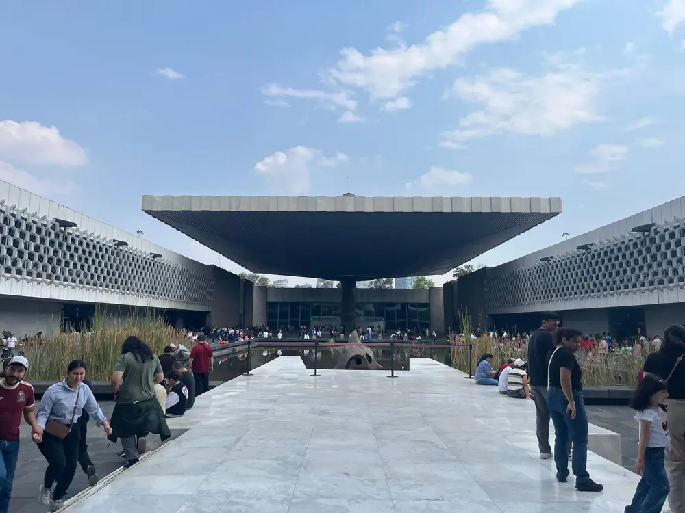 Visitors beneath the broad canopy in the courtyard of the National Museum of Anthropology.