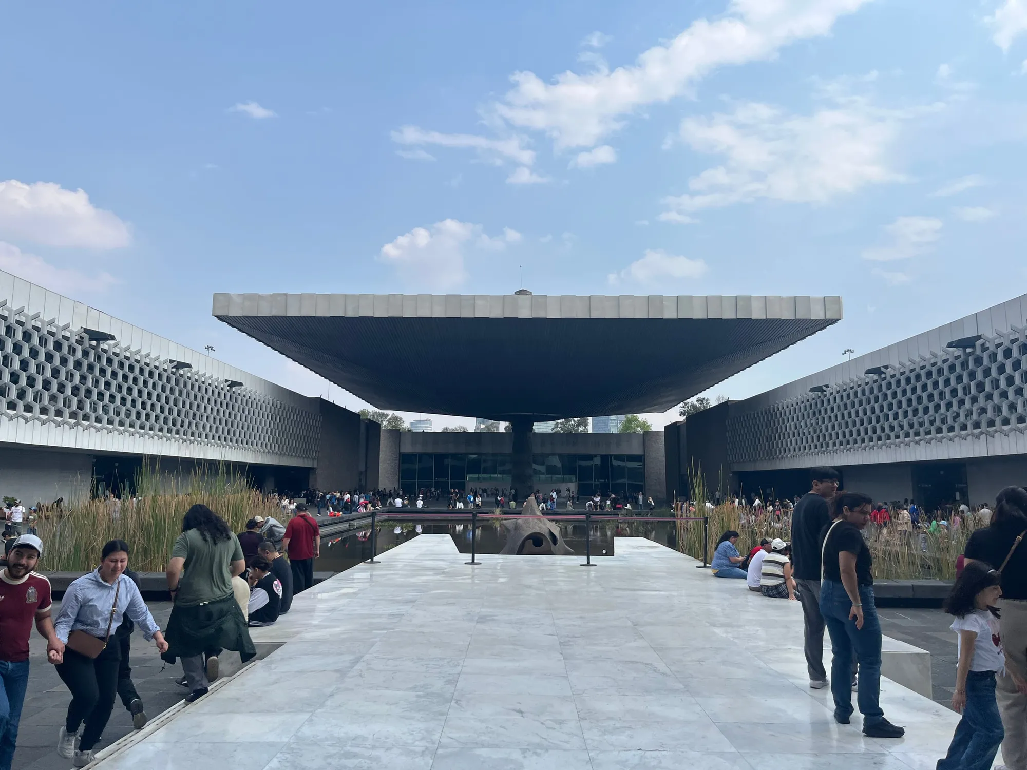 Visitors beneath the broad canopy in the courtyard of the National Museum of Anthropology.
