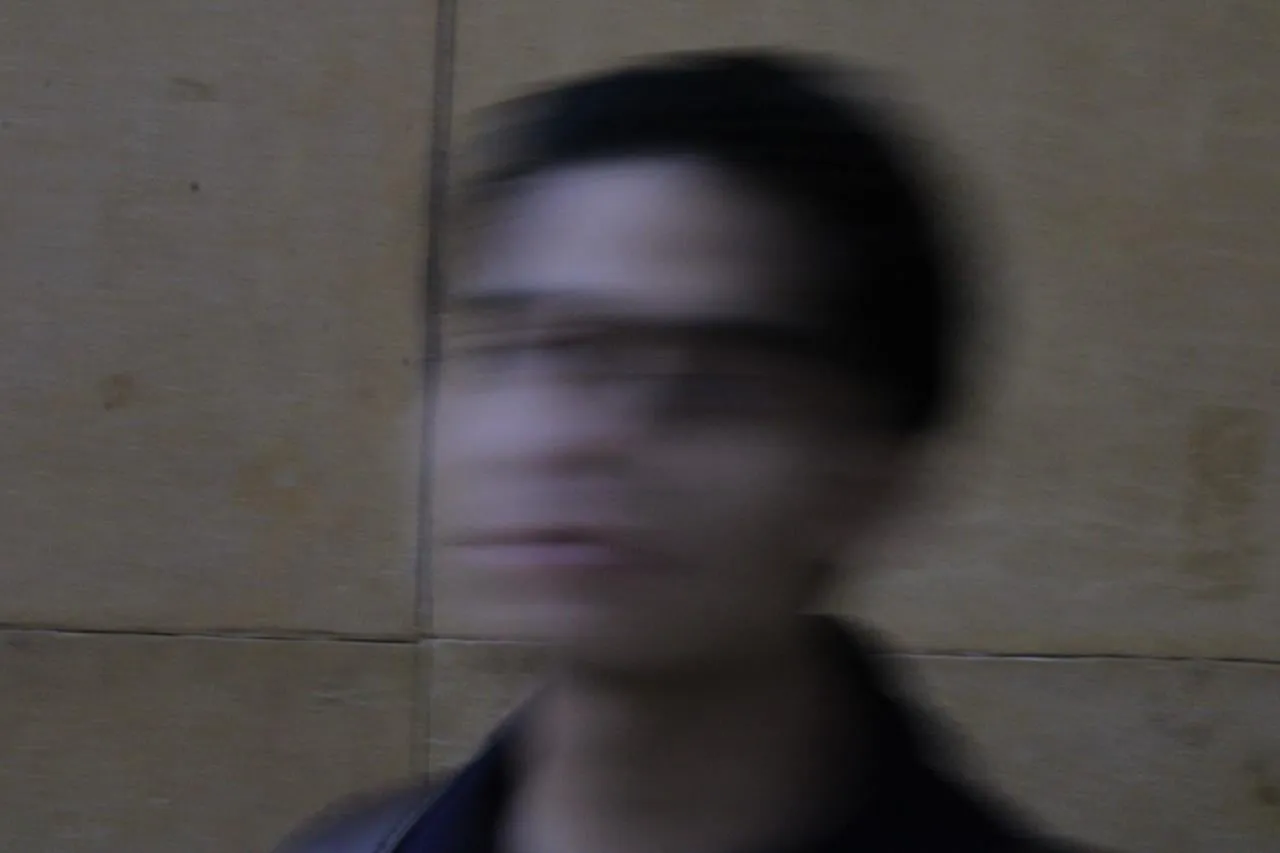A motion-blurred portrait in front of a beige stone wall.